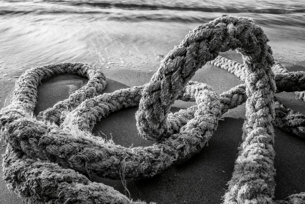 Tangled rope on a sandy shoreline symbolizing the stress mess we need to untangle