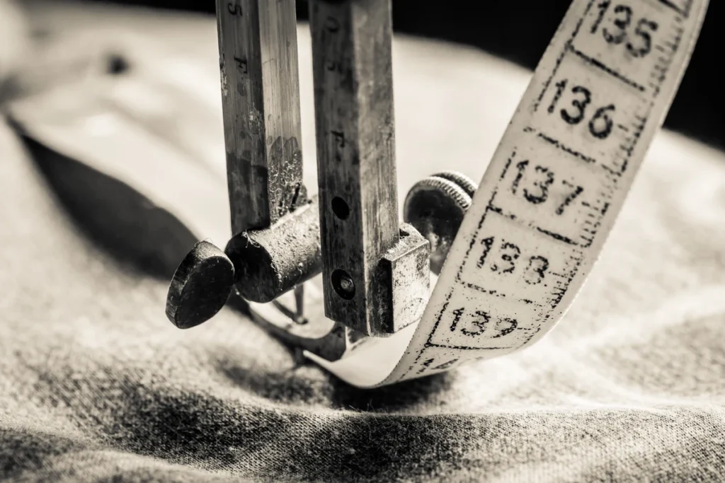 Vintage sewing machine foot and measuring tape in sepia representing how we measure stress with the wrong tools