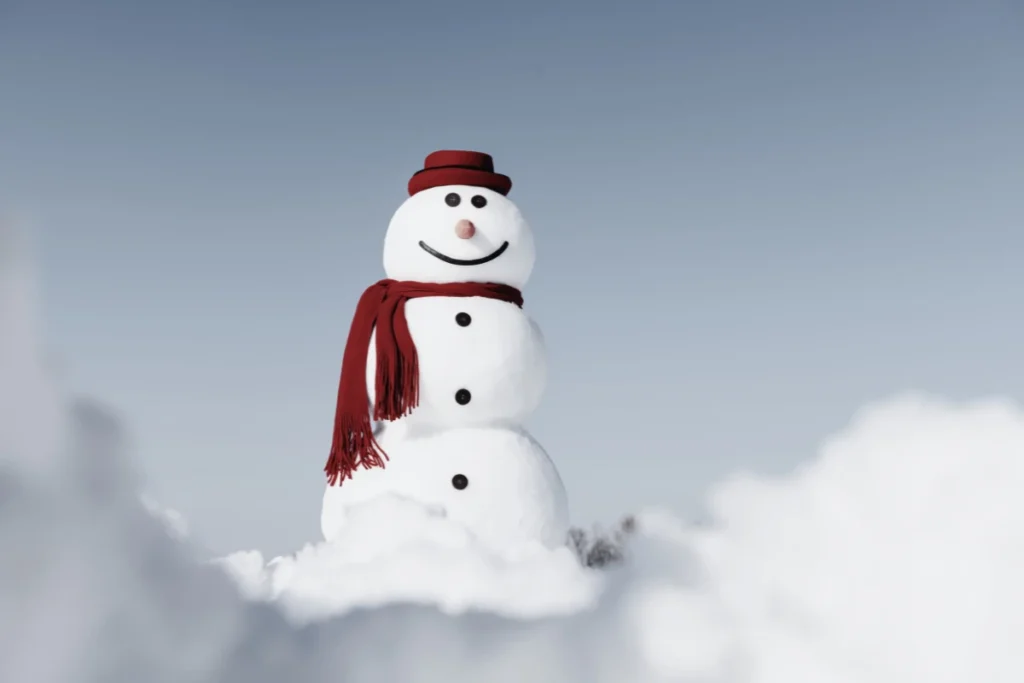 Smiling snowman with a red scarf and hat against a blue sky representing the snowman metaphor for workplace toxicity