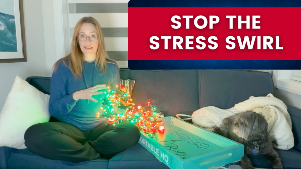Allison Graham sitting on her couch with tangled up Christmas Lights that are red, yellow, and green with a small black dog watching her.