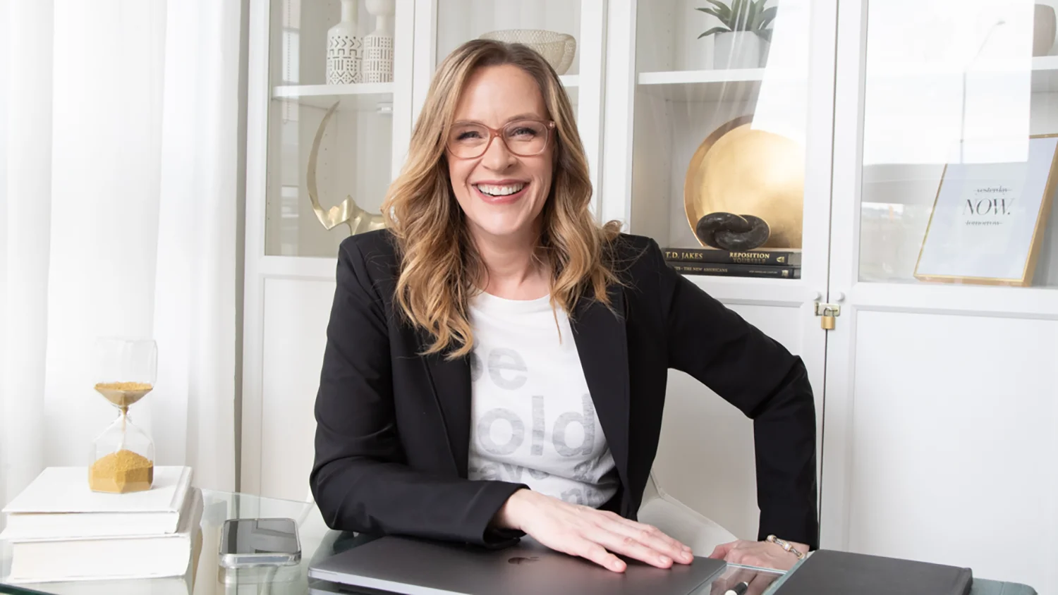 Allison Graham at her desk with hourglass